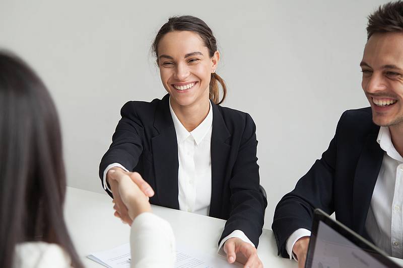 Smiling female hr handshaking employee welcoming hired worker, new team member, cheerful positive businesswoman shaking hand of partner satisfied with deal, making good first impression concept